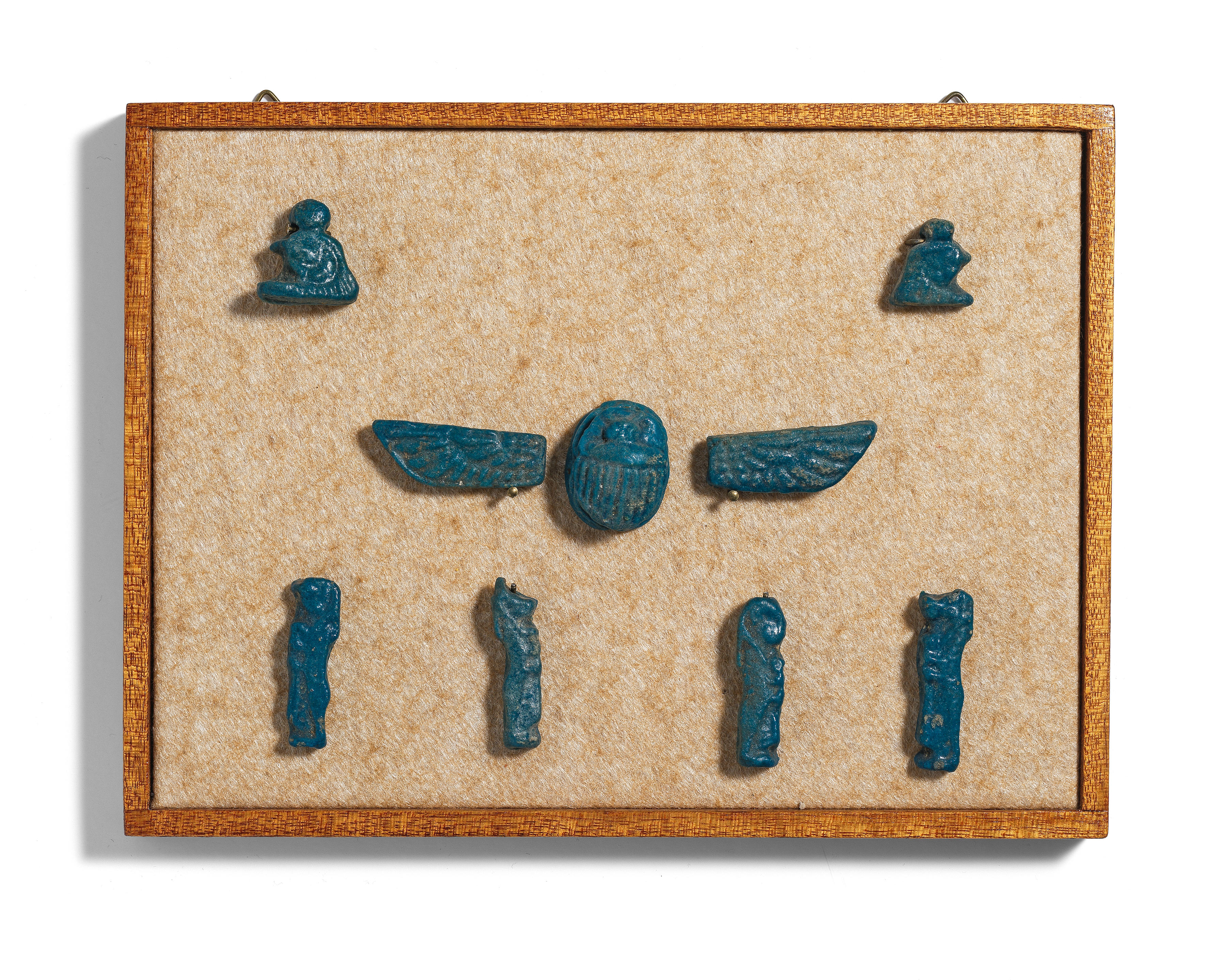 Appraisal: A FRAMED GROUP OF EGYPTIAN BLUE GLAZED FAIENCE AMULETS A