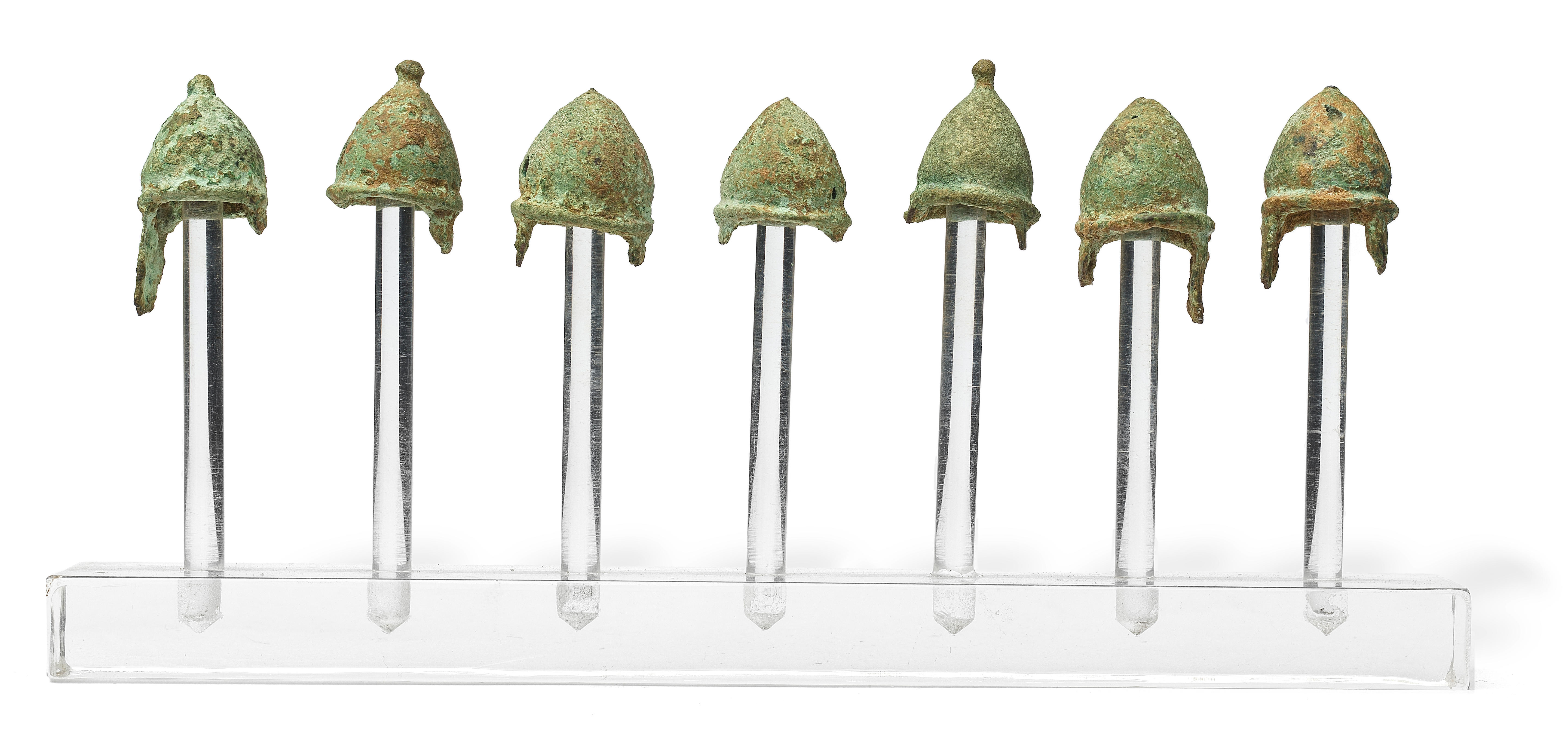 Appraisal: A GROUP OF SEVEN GREEK BRONZE MINIATURE VOTIVE PILOS HELMETS