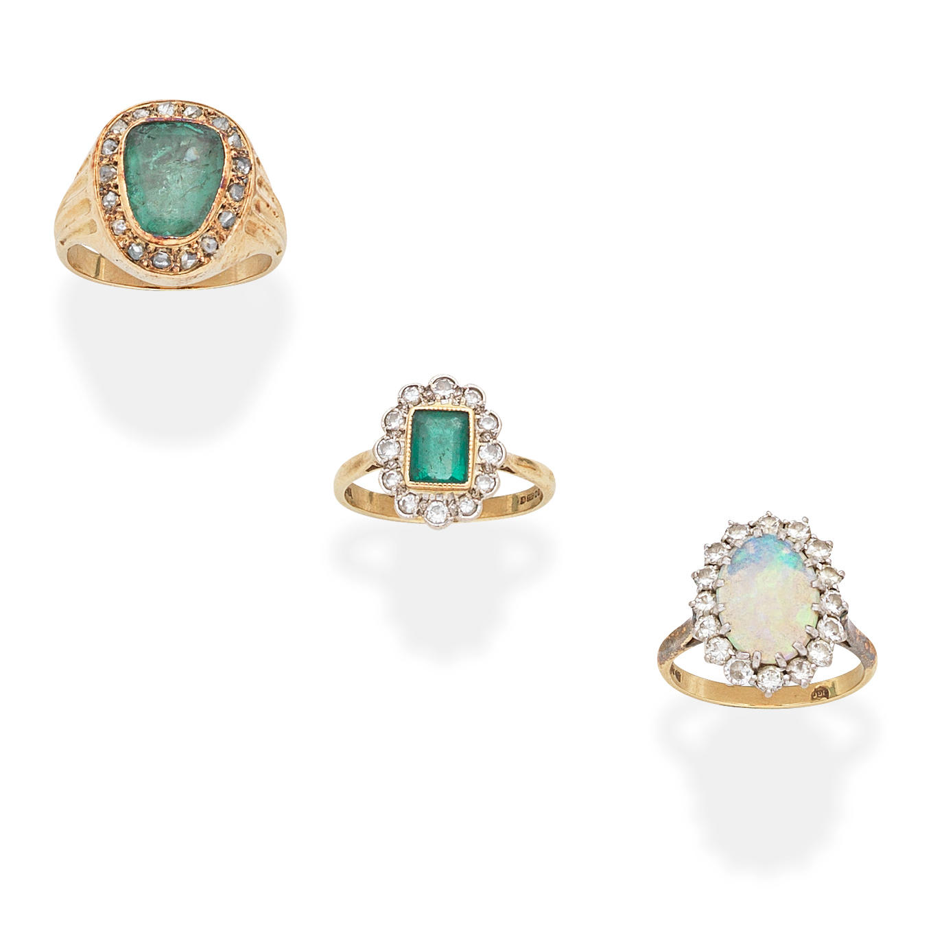 Appraisal: THREE GEM-SET AND DIAMOND RINGS st The step-cut emerald within