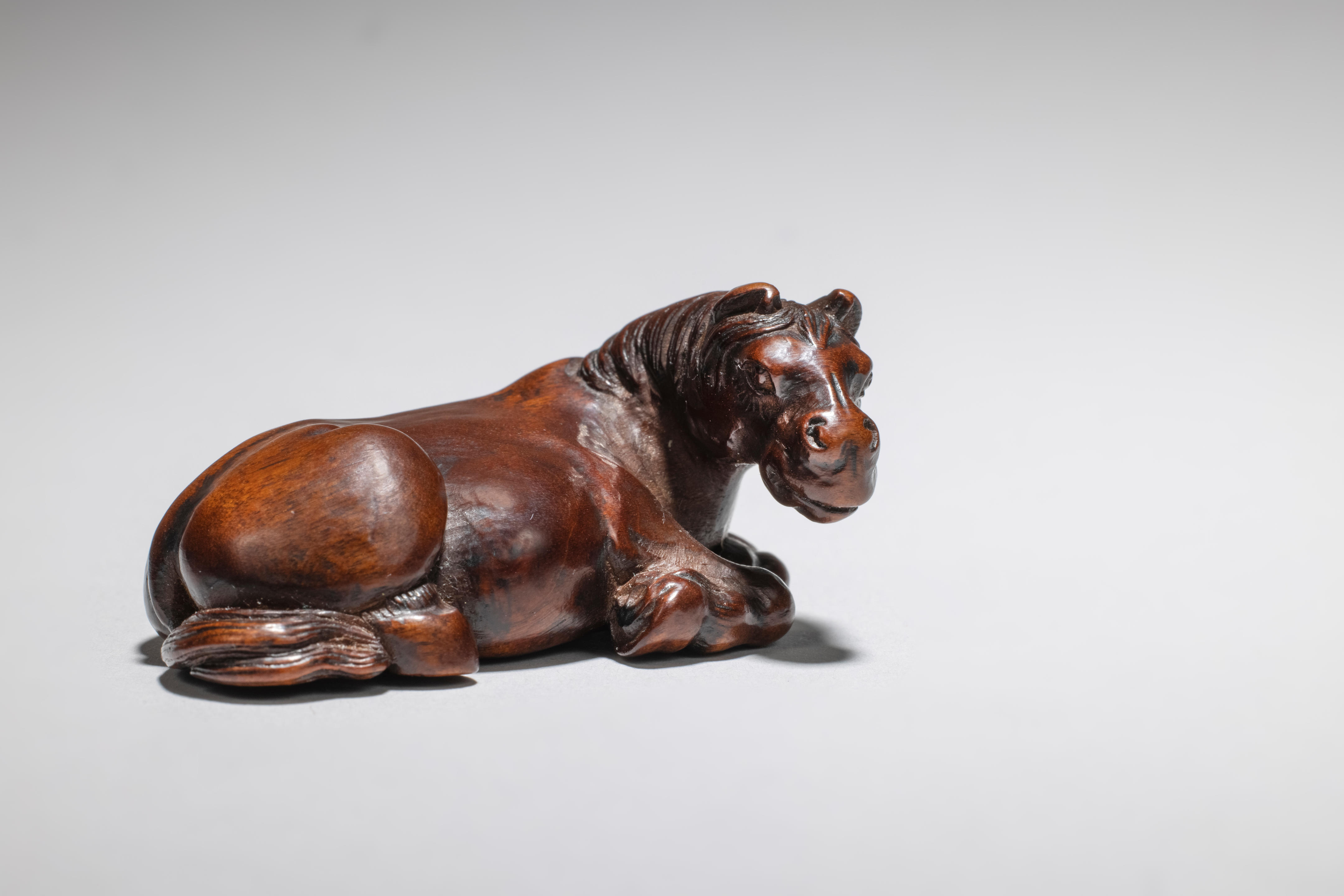 Appraisal: NETSUKE EN BOIS REPR SENTANT UN CHEVAL COUCH XIXe si