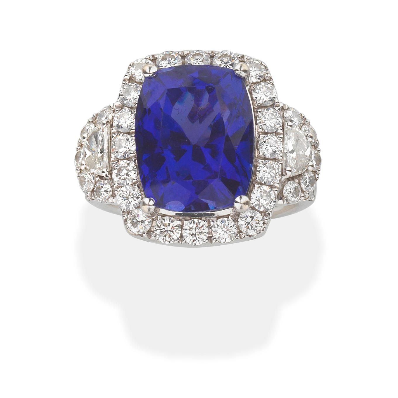 Appraisal: TANZANITE AND DIAMOND CLUSTER RING The cushion-shaped tanzanite between half-moon