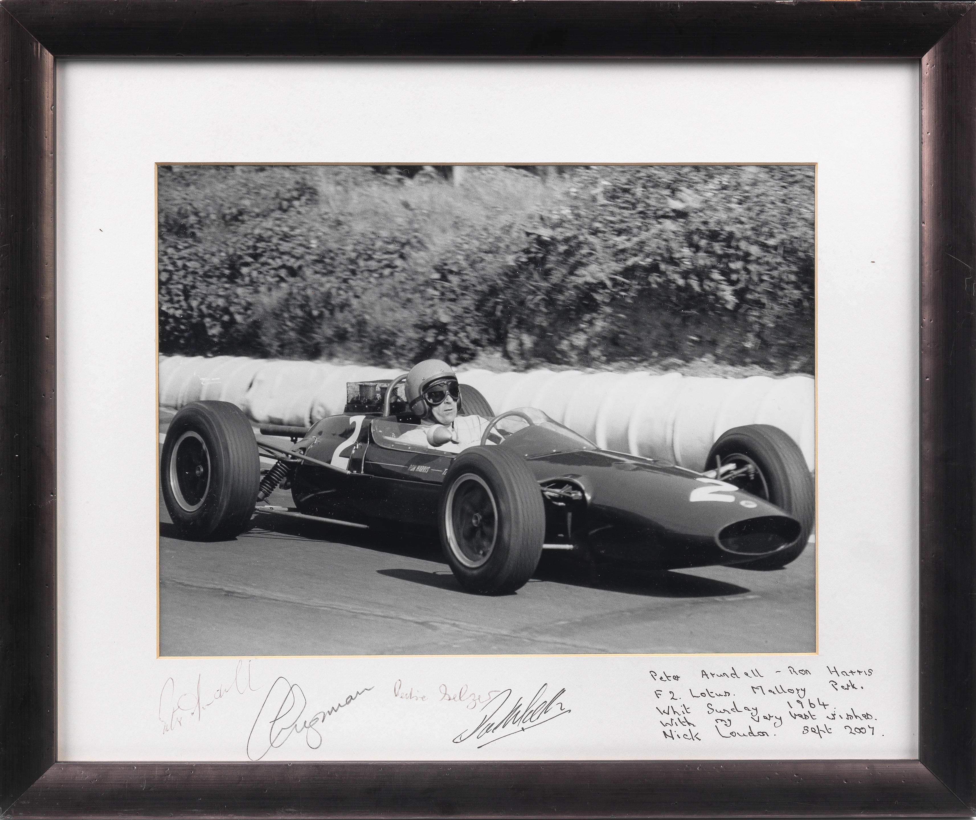 Appraisal: A FRAMED PHOTOGRAPH OF PETER ARUNDELL DRIVING THE LOTUS F