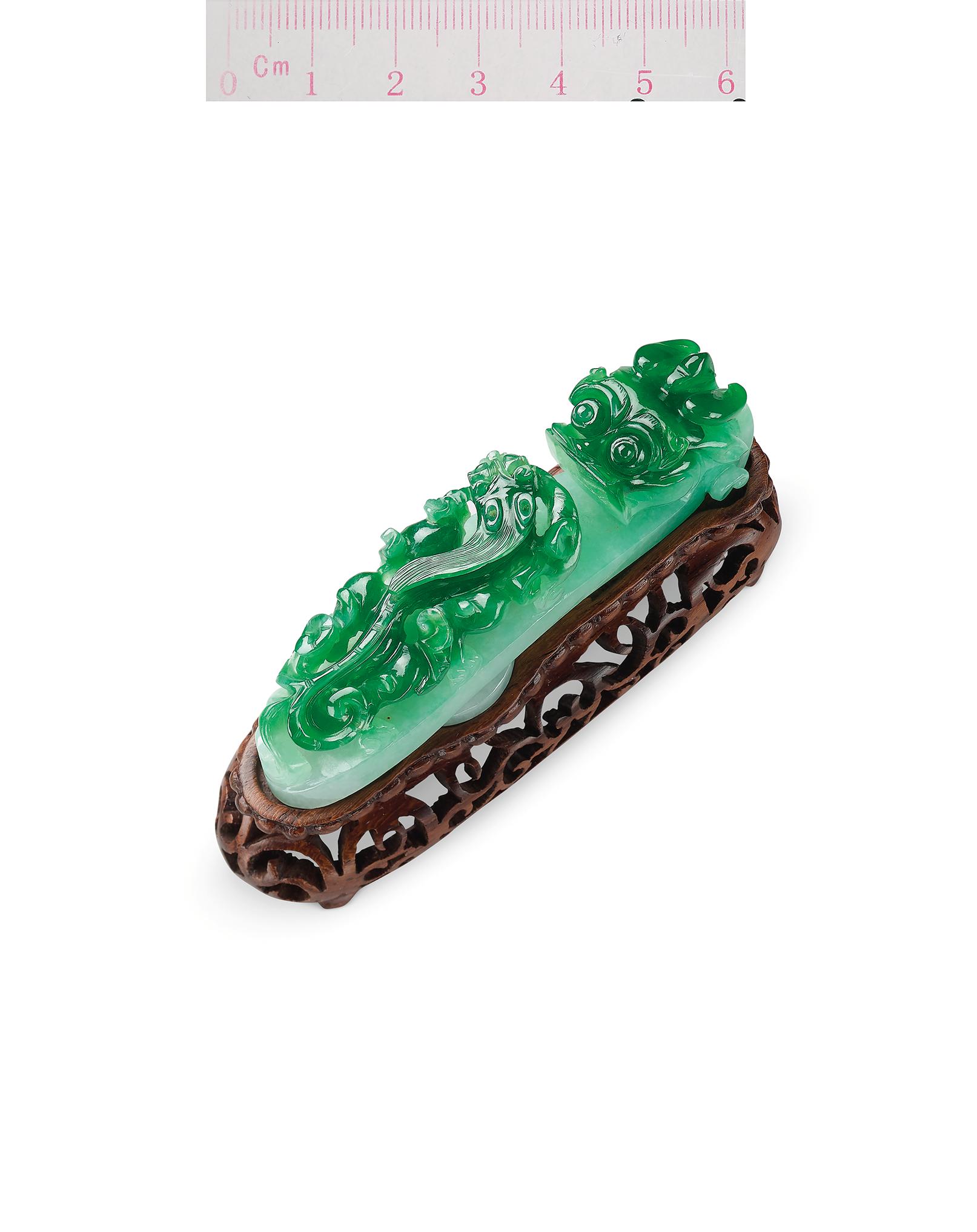 Appraisal: RETICULATED JADEITE 'DRAGON' ORNAMENT BELT HOOK The reticulated semi-translucent bicoloured