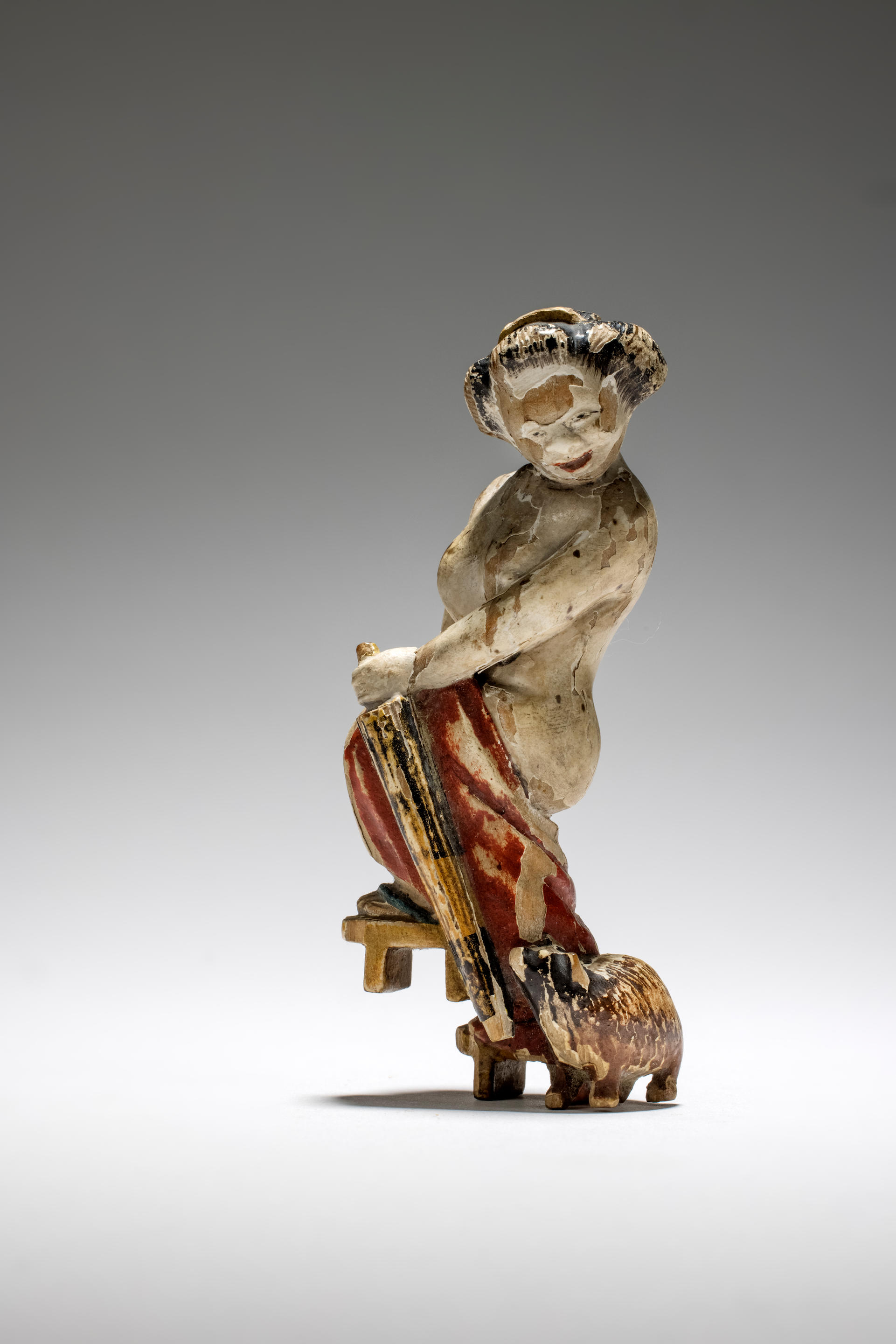 Appraisal: NETSUKE EN BOIS PEINT REPR SENTANT UNE COURTISANE ACCOMPAGN E