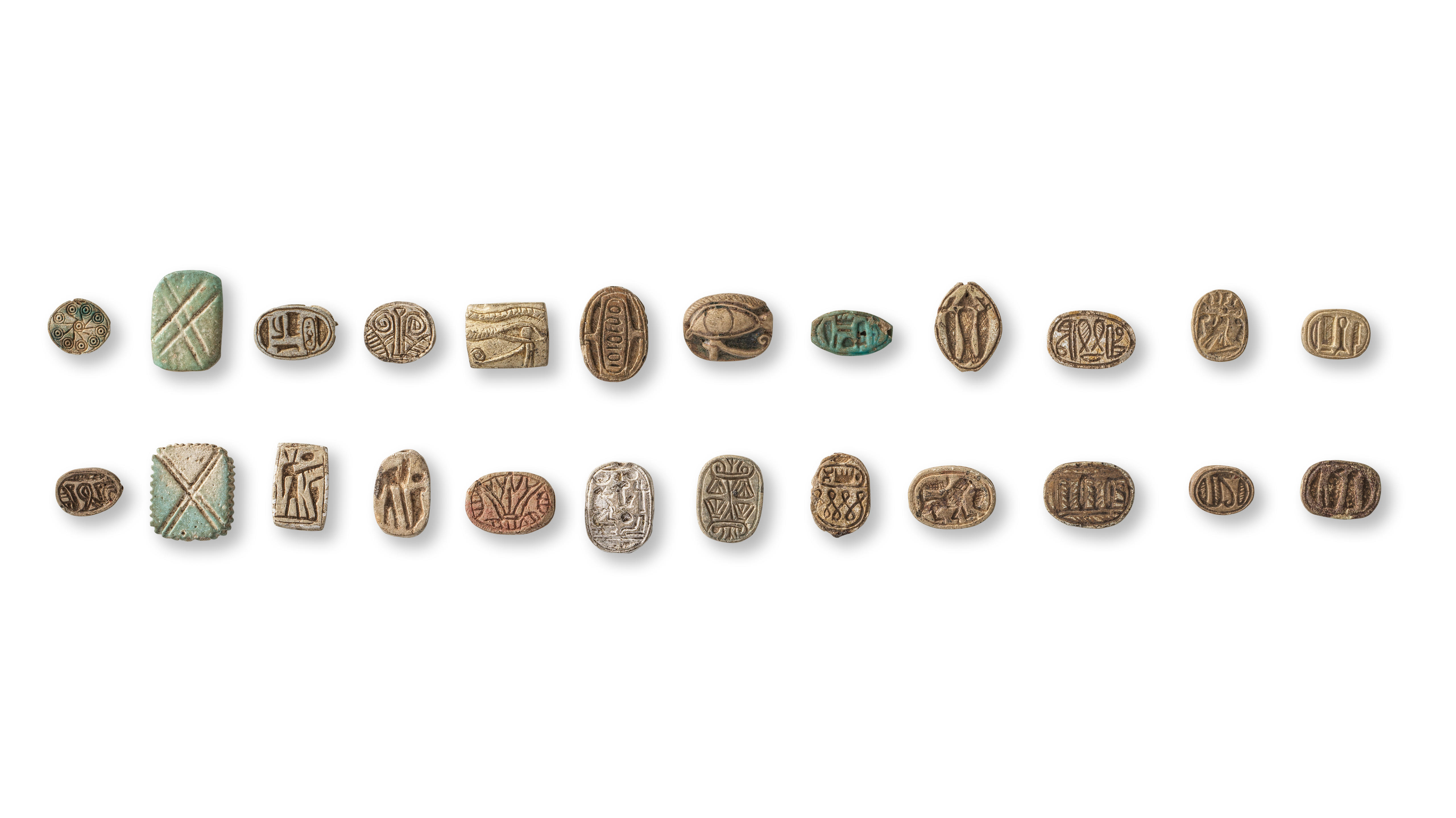 Appraisal: A GROUP OF TWENTY-FOUR EGYPTIAN STEATITE AND FAIENCE SCARABS COWROIDS