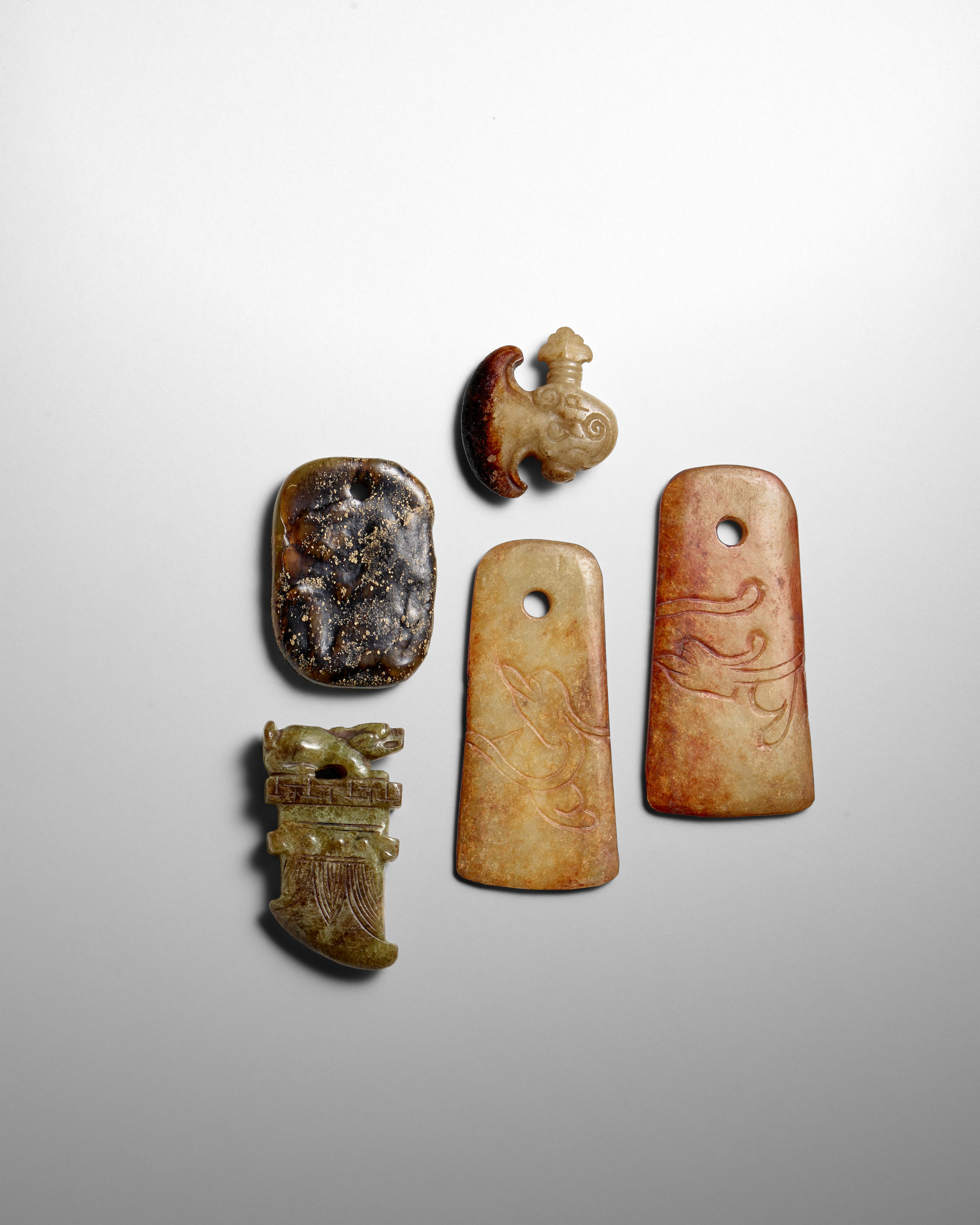 Appraisal: FIVE ARCHAISTIC JADE AXE-SHAPED PENDANTS Late Qing Dynasty Comprising two