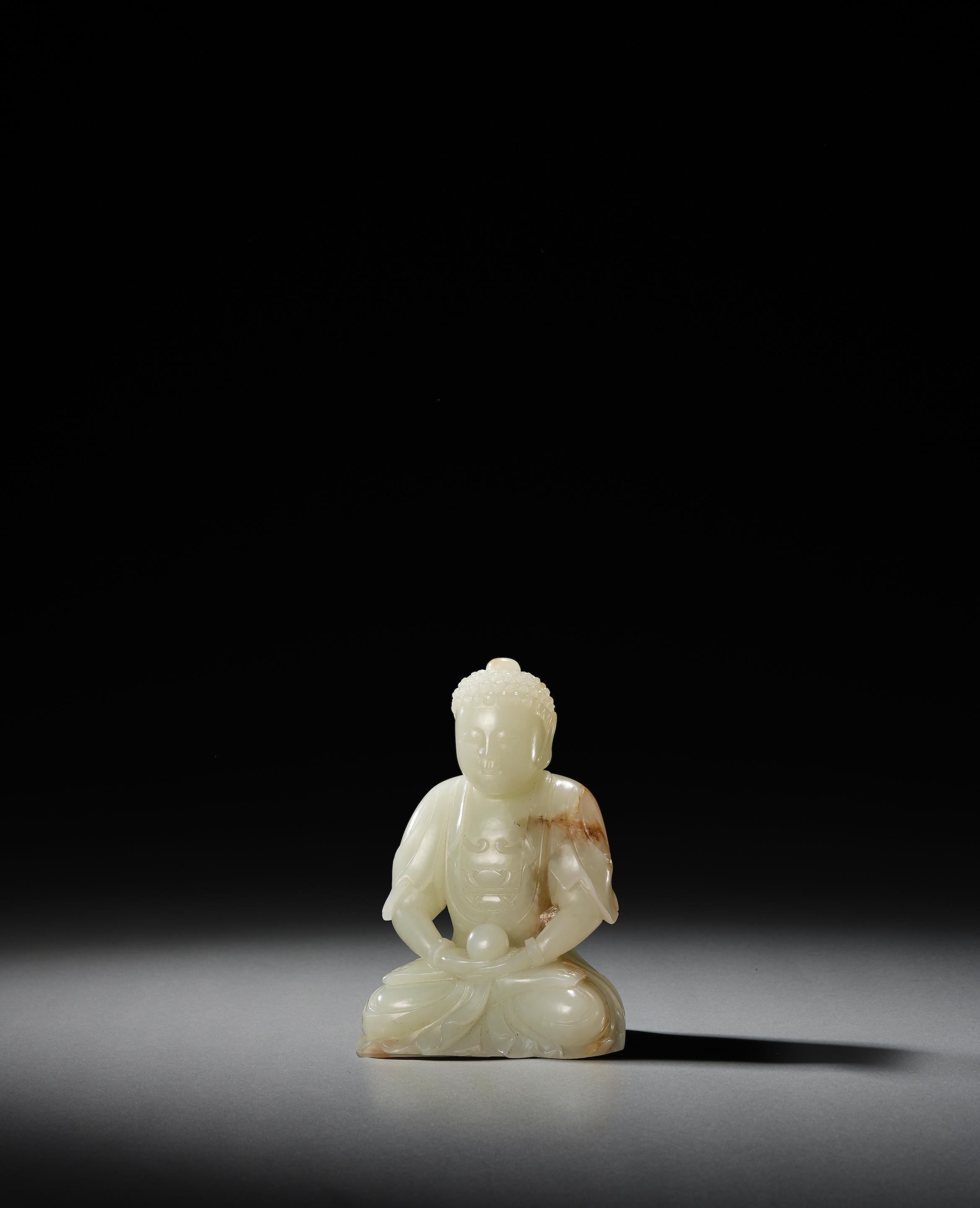 Appraisal: A WHITE AND RUSSET JADE CARVING OF SEATED BUDDHA th