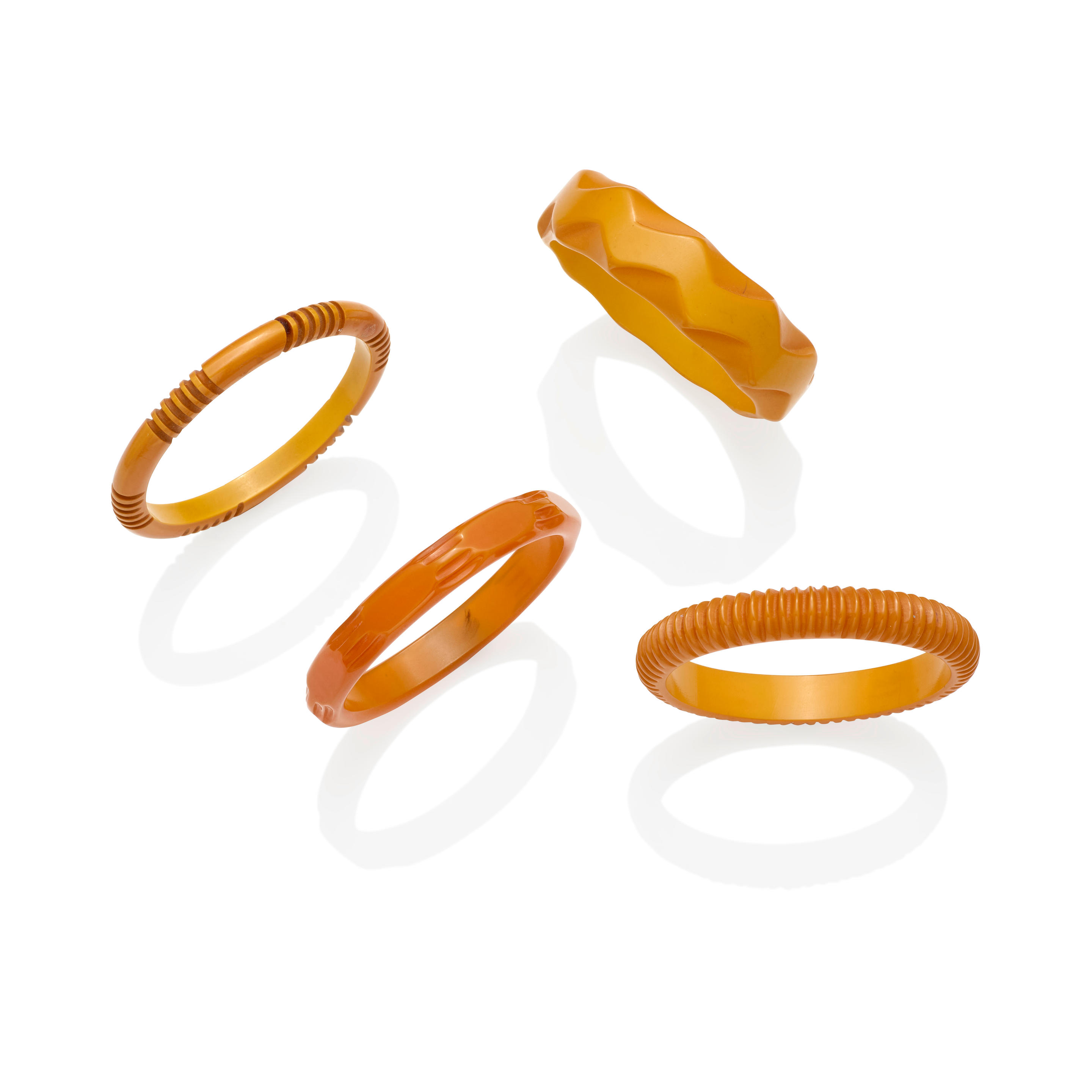 Appraisal: FOUR CARVED BAKELITE BRACELETS IN CREAM AND BUTTERSCOTCH diameter in