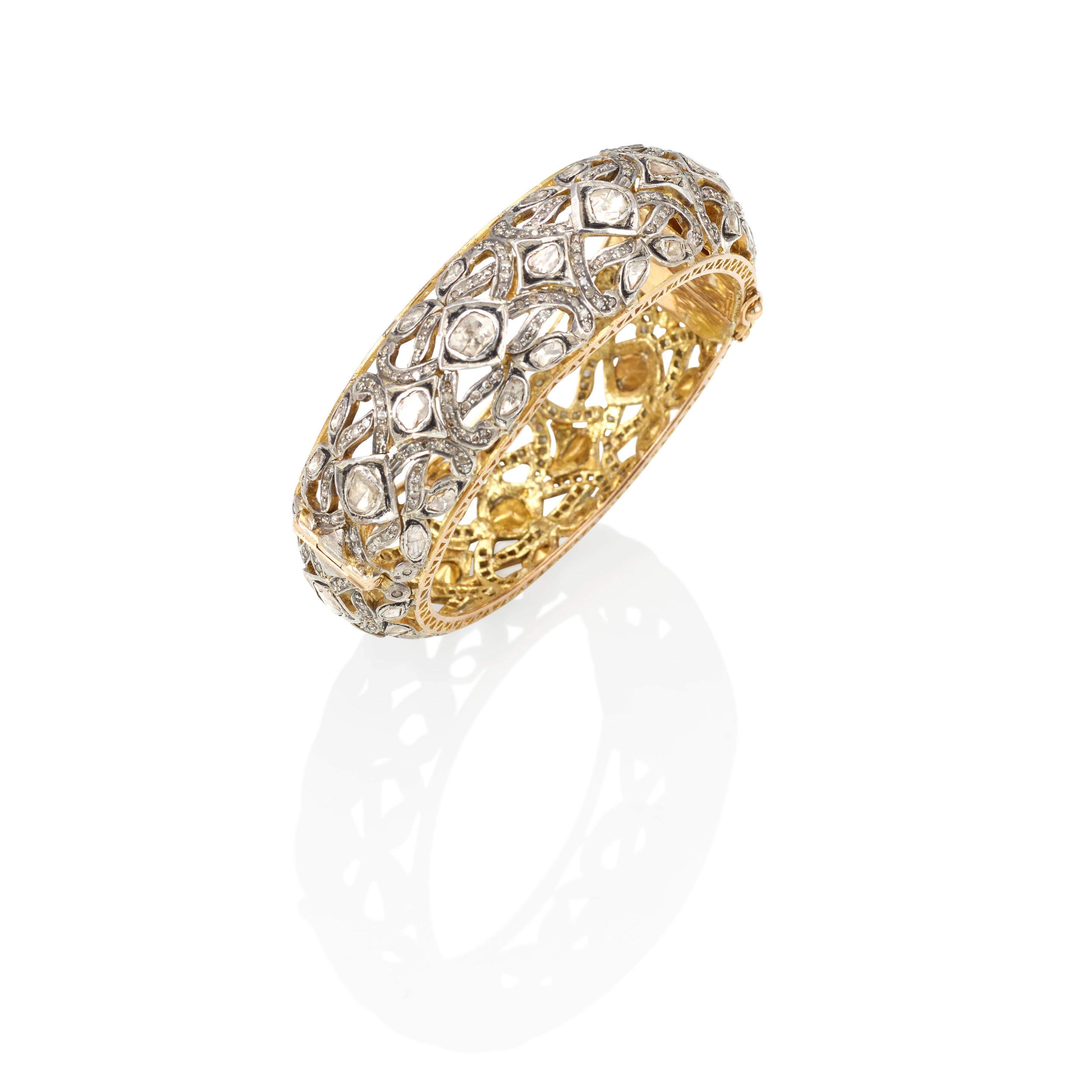 Appraisal: A SILVER-TOPPED GOLD AND DIAMOND HINGED BANGLE Single-cut diamonds weighing