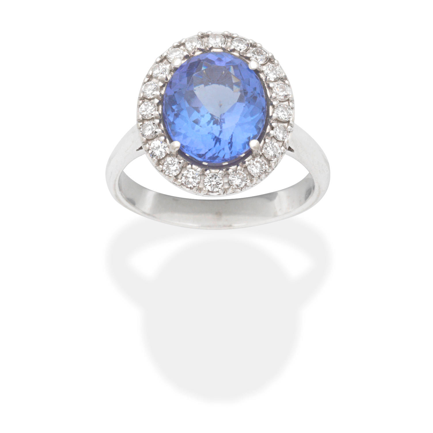 Appraisal: TANZANITE AND DIAMOND CLUSTER RING The oval-cut tanzanite within a