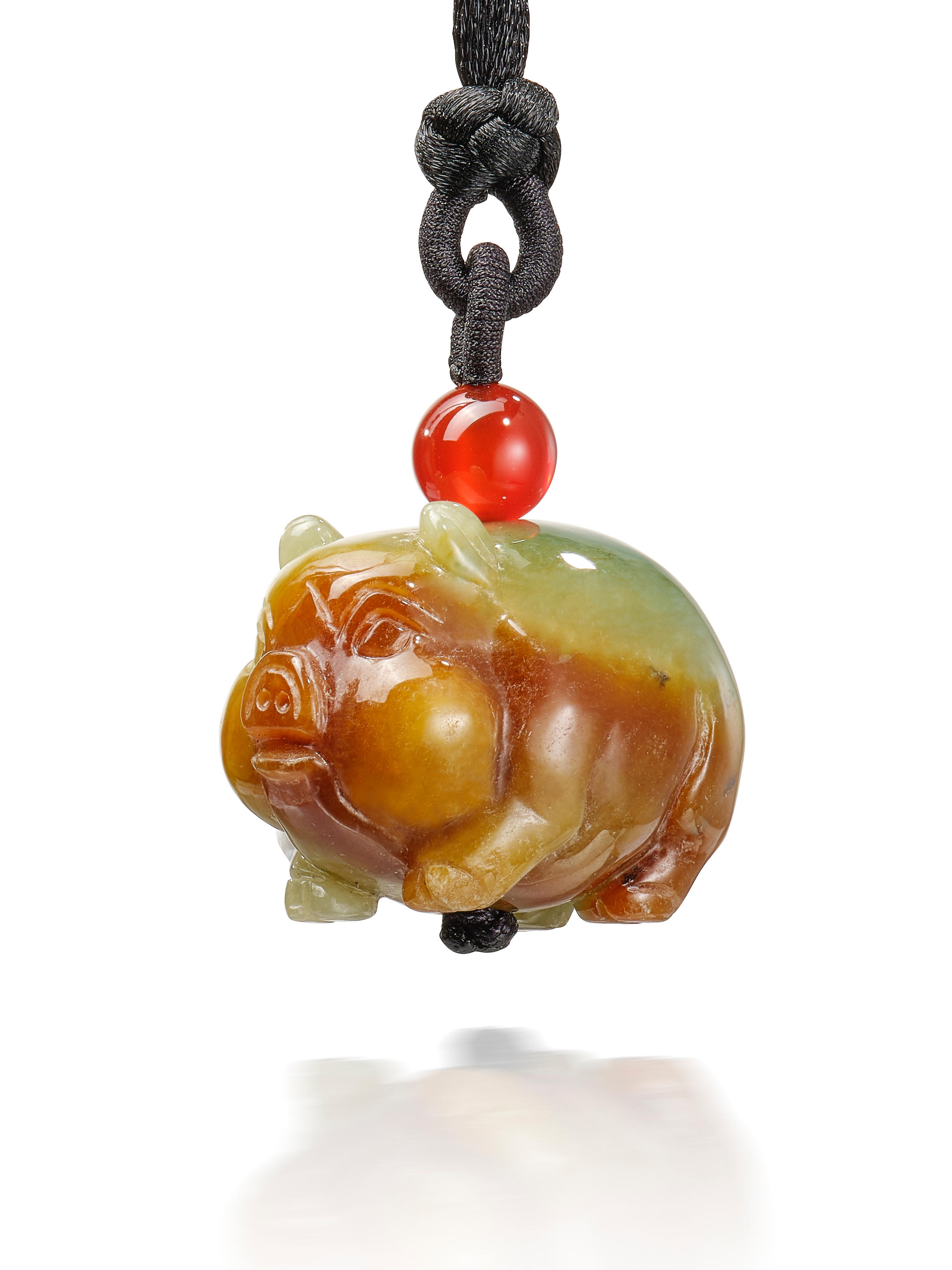 Appraisal: CARVED JADEITE 'PIGLET' AND AMBER PENDANT NECKLACE The semi-translucent carved