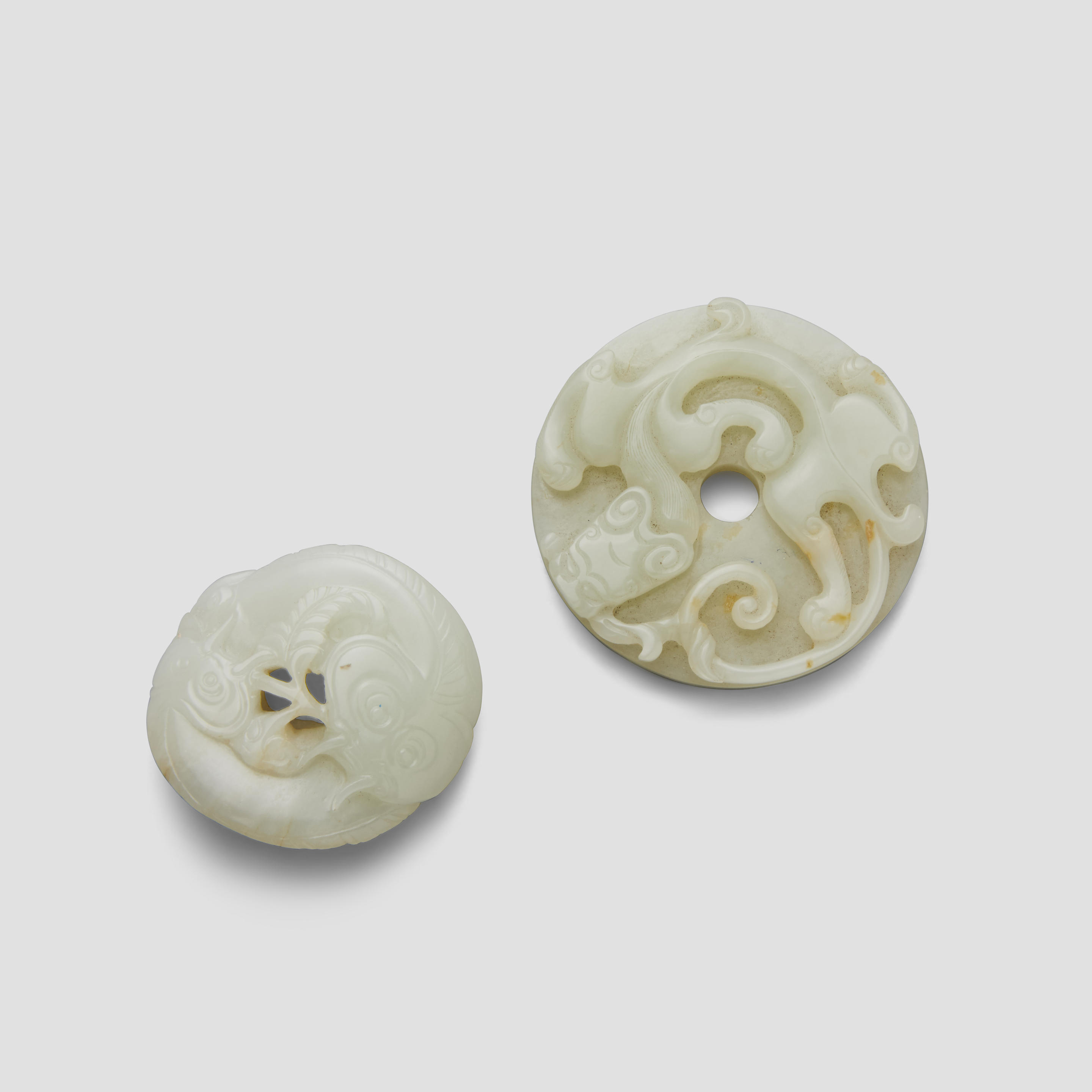 Appraisal: TWO CIRCULAR JADE PENDANTS Republic period and later The first