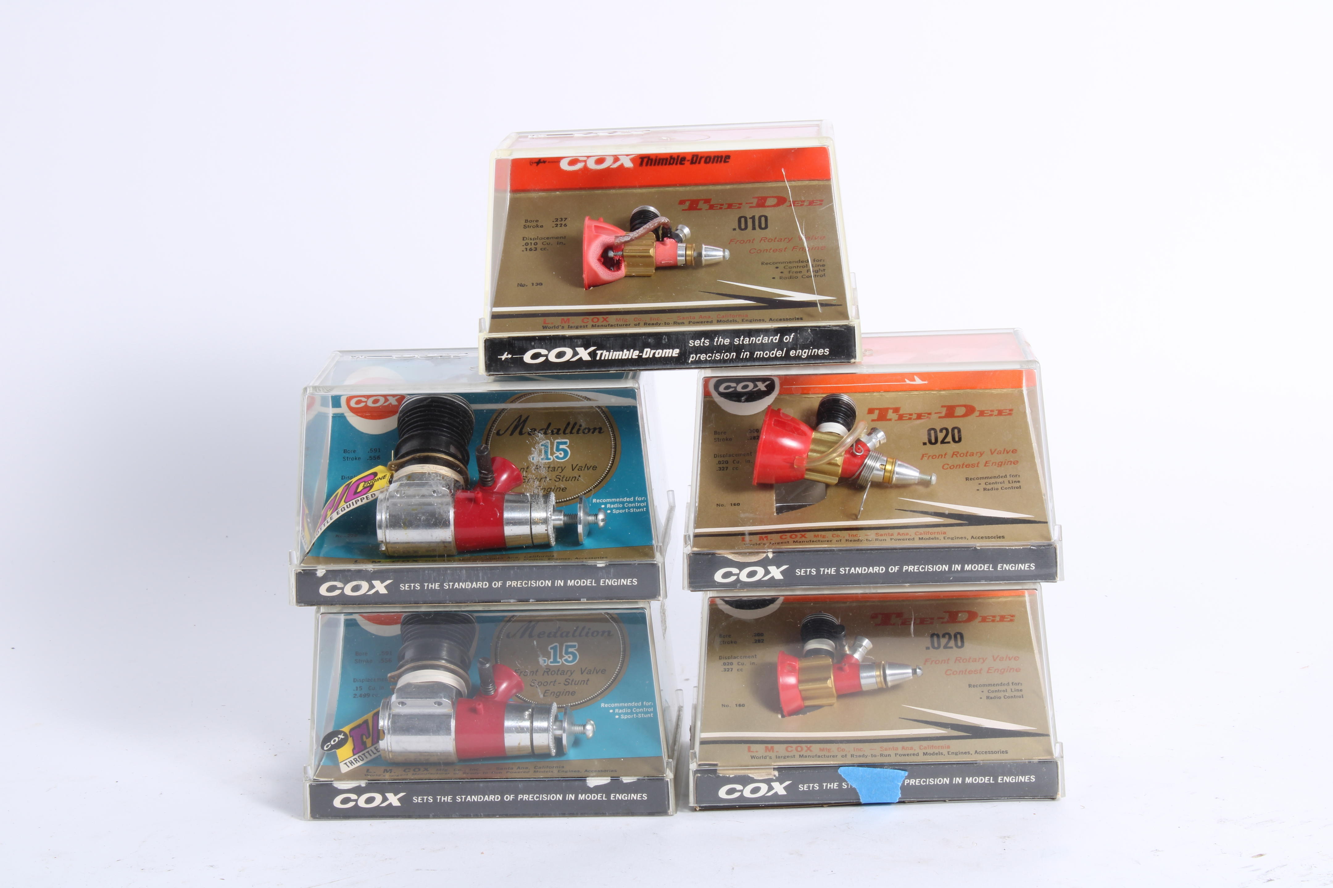 Appraisal: FIVE COX GAS POWERED MINIATURE ENGINES IN PERSPEX SHOP DISPLAY