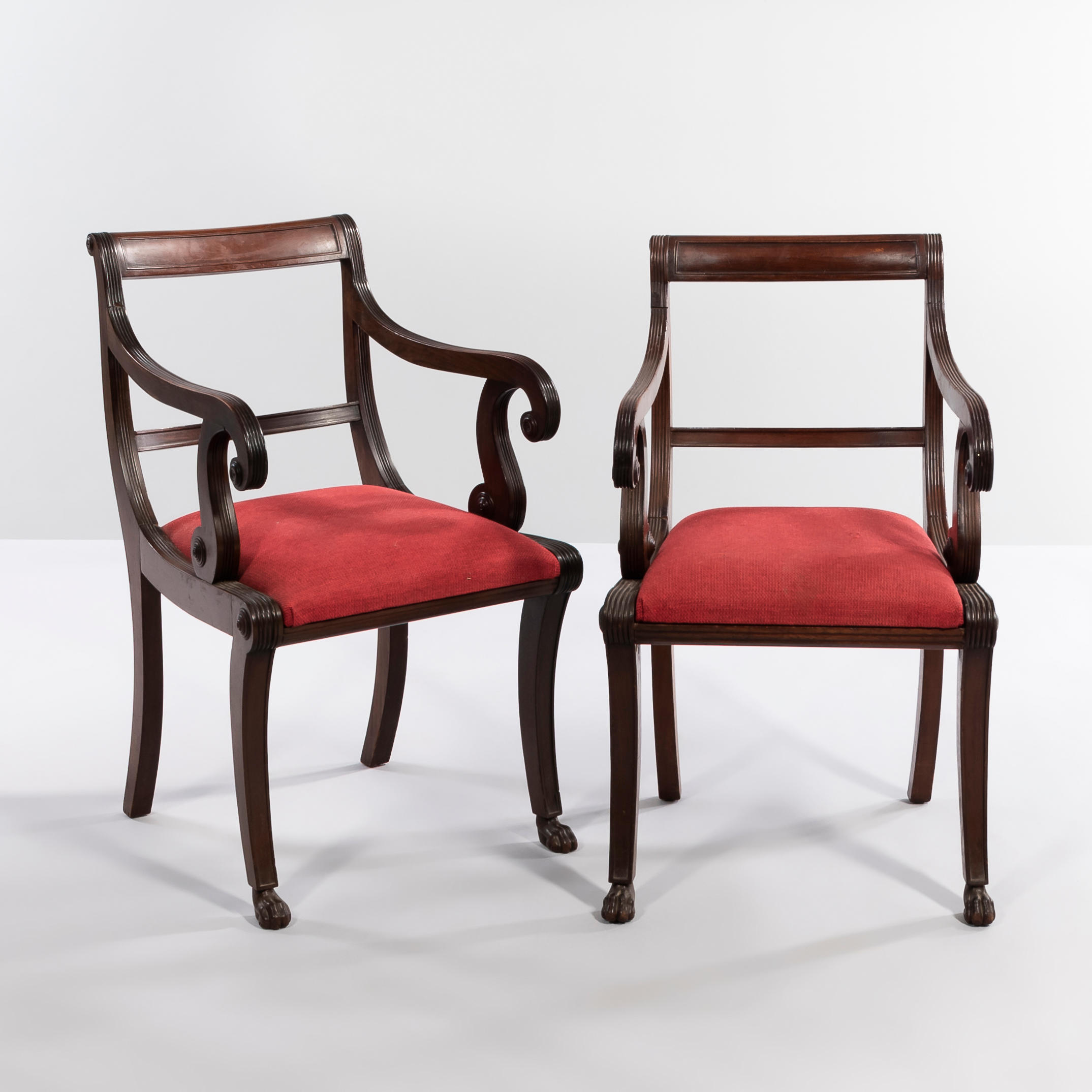 Appraisal: PAIR OF CLASSICAL-STYLE MAHOGANY ARMCHAIRS with scrolled arms and red