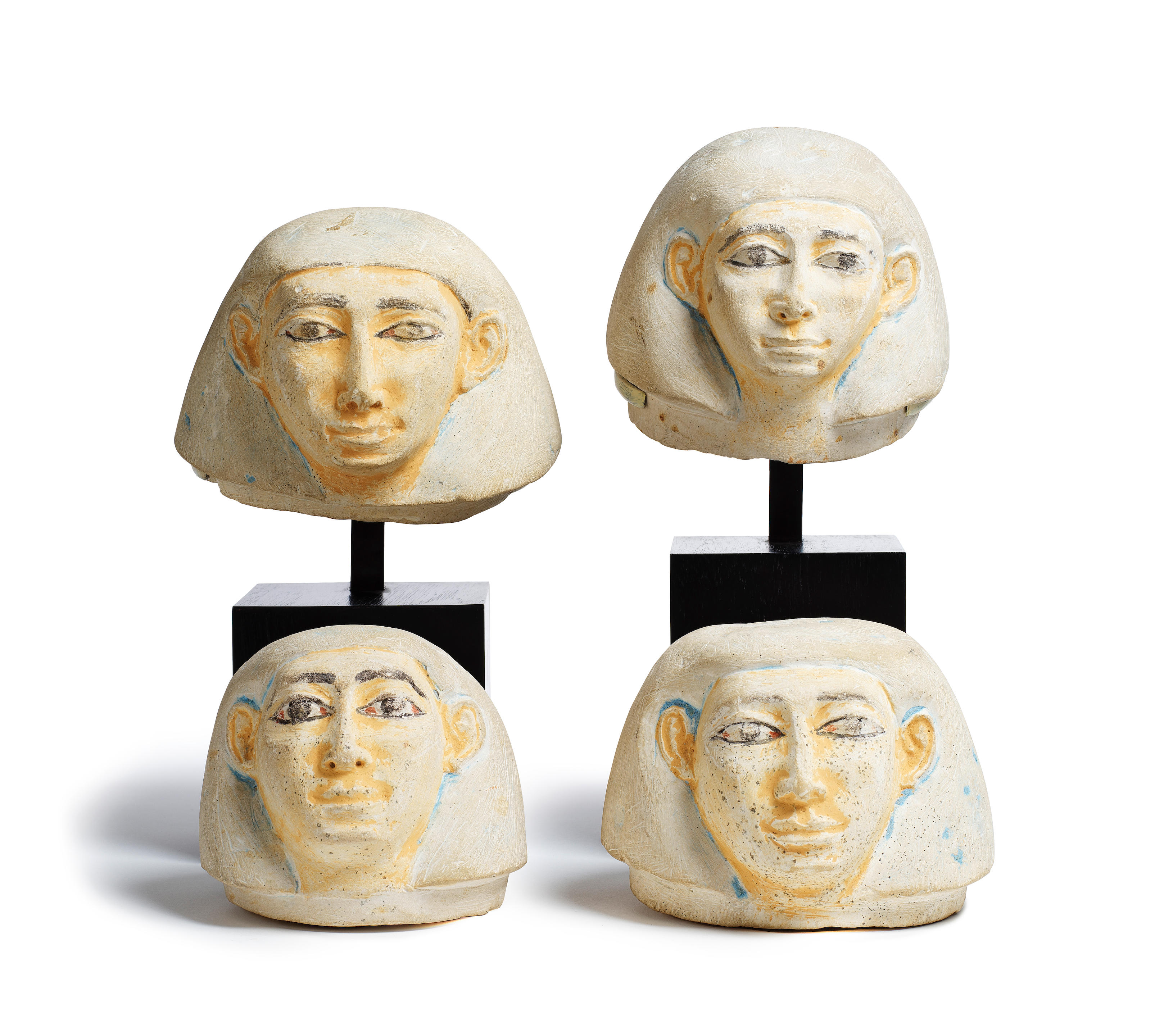 Appraisal: FOUR EGYPTIAN LIMESTONE HUMAN-HEADED CANOPIC JAR LIDS Four Egyptian limestone