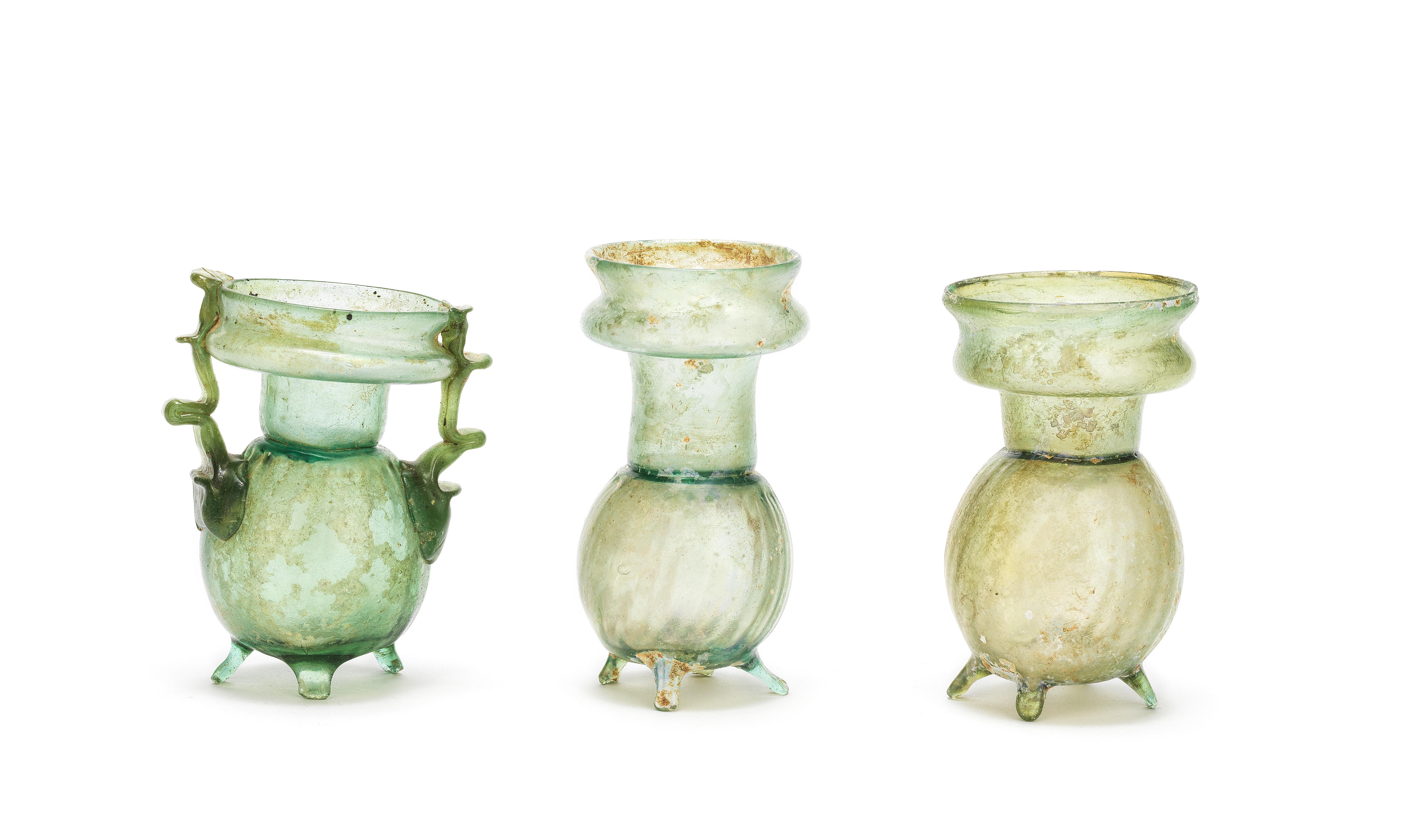 Appraisal: THREE ROMAN GREEN GLASS FOOTED SPRINKLER FLASKS Three Roman green