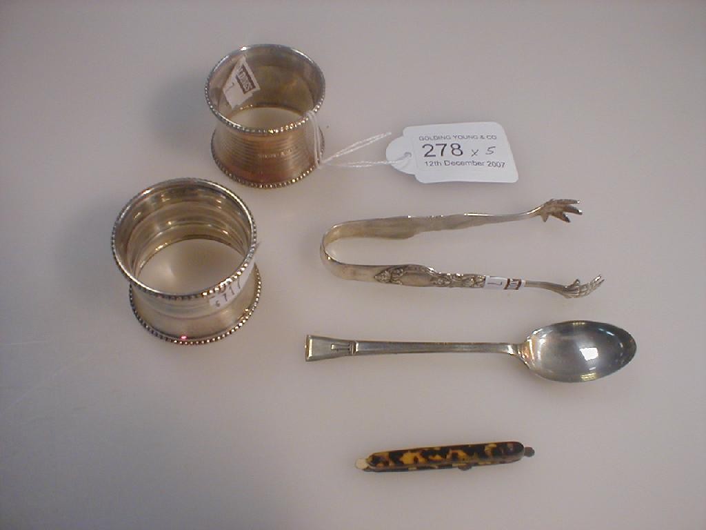 Appraisal: Two serviette rings sugar bows silver spoon and miniature penknife