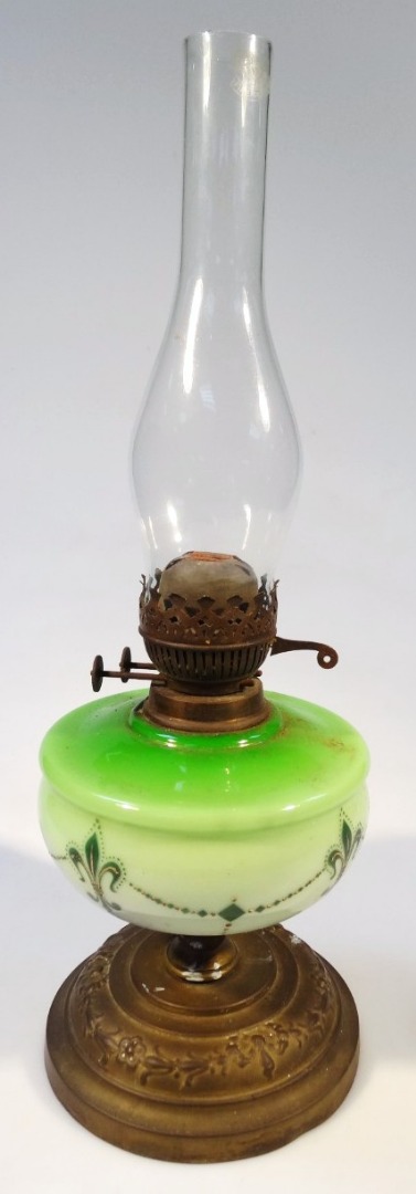 Appraisal: An Edwardian oil lamp with plain glass chimney and green