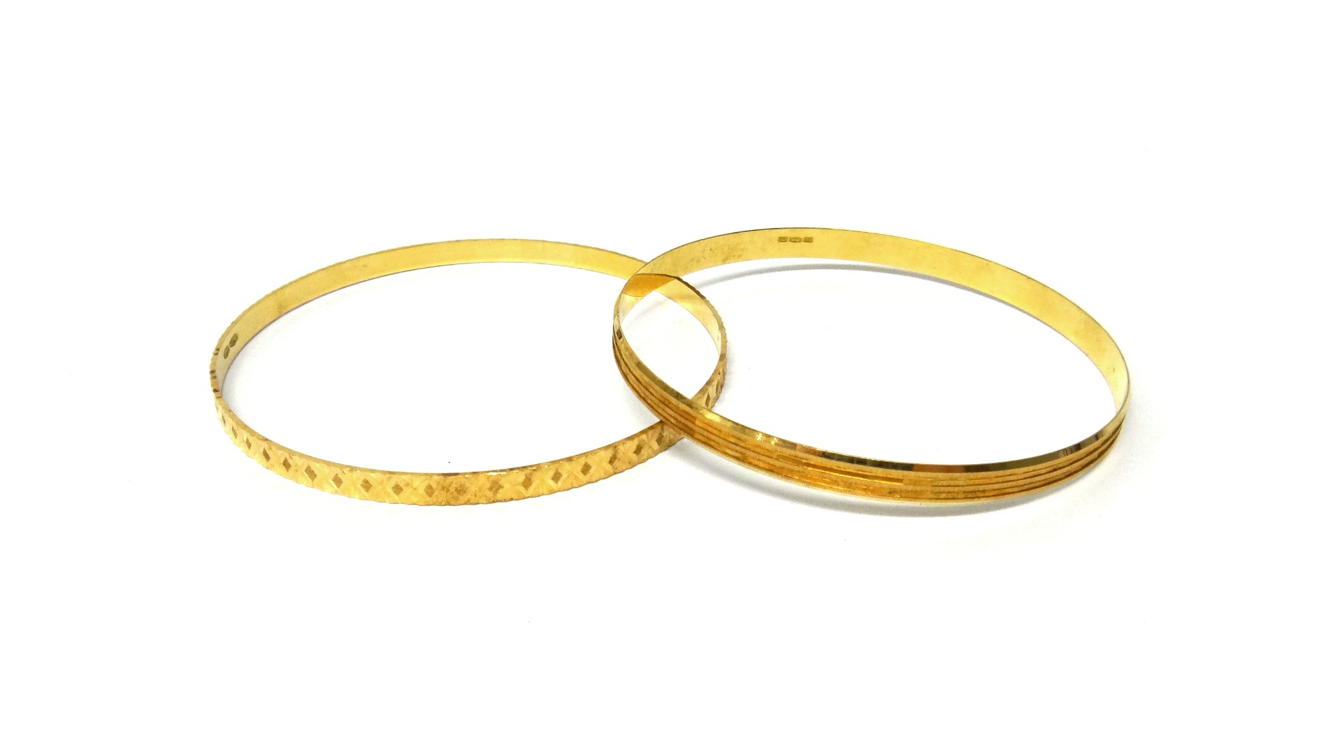 Appraisal: Two gold circular bangles with differing engraved decoration to each