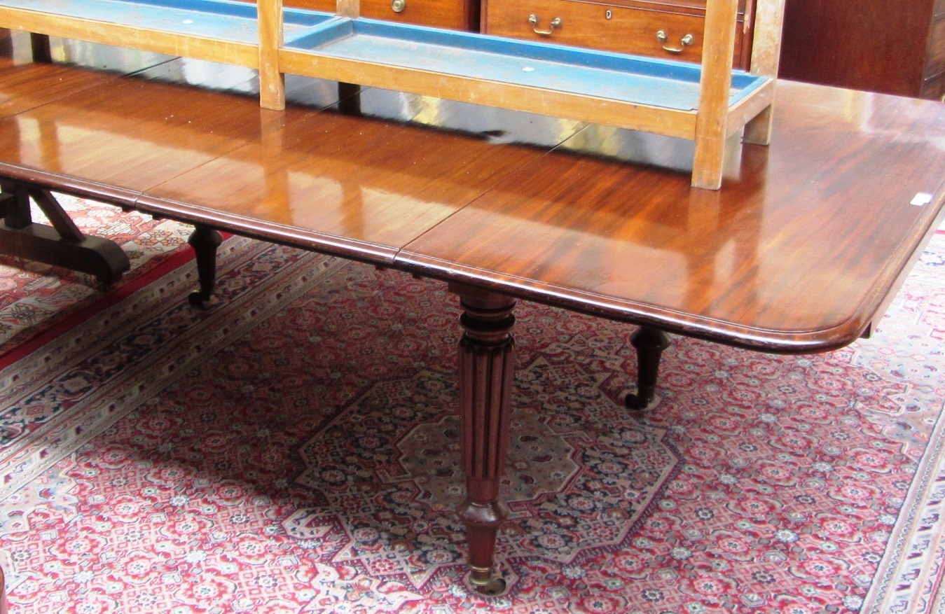 Appraisal: A th century mahogany extending dining table on tapering reeded