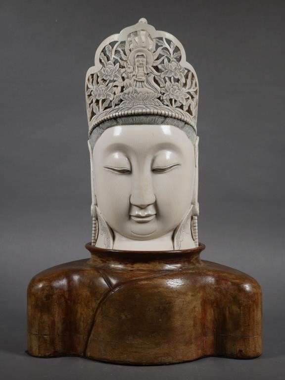 Appraisal: A large Chinese ivory carved Buddha's head resting on rosewood