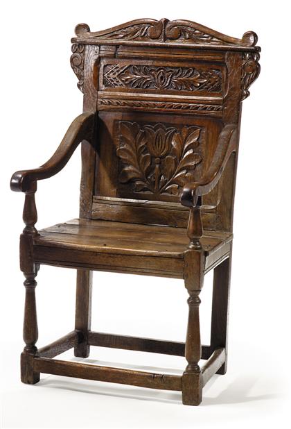 Appraisal: English oak armchair The S-scroll top above a tulip motif