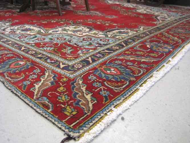 Appraisal: PERSIAN TABRIZ CARPET central floral medallion design on plain red