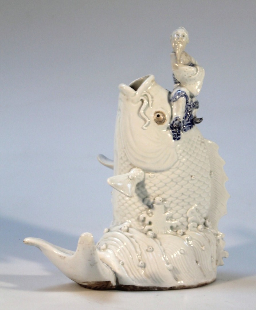 Appraisal: A Chinese glazed earthenware figure of a fish aside gentleman