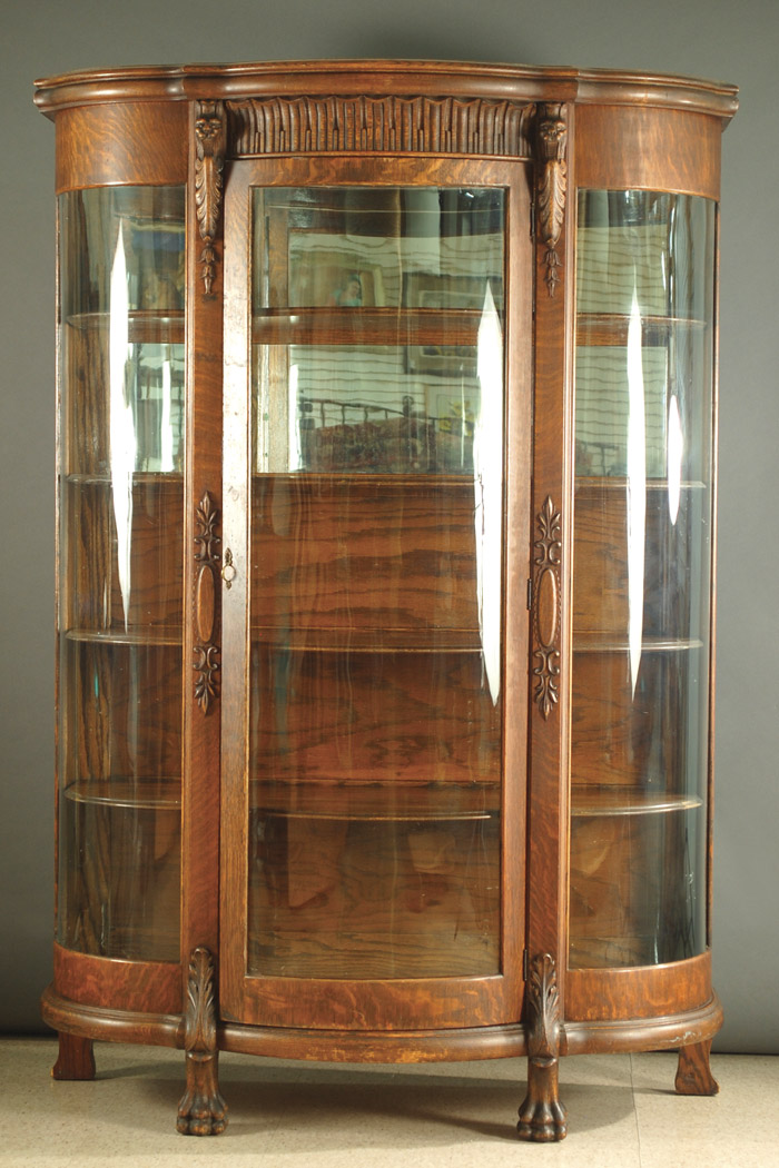 Appraisal: AN OAK AND CURVED GLASS CHINA CABINET American c having