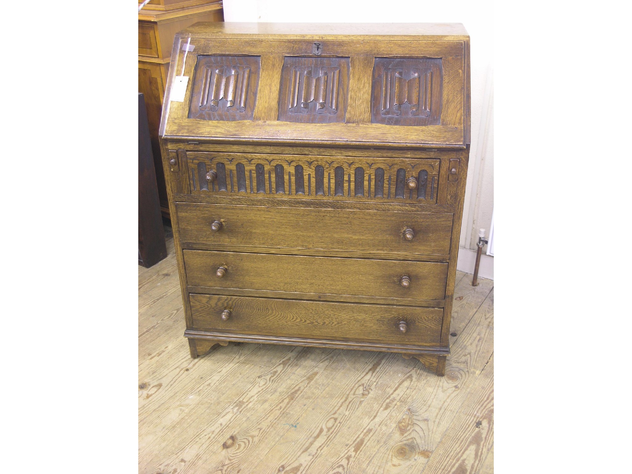 Appraisal: An oak bureau linenfold fall-front above four long drawers ft