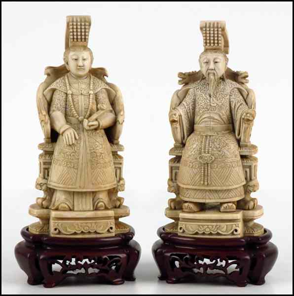 Appraisal: PAIR OF CARVED IVORY FIGURES OF A SEATED EMPEROR AND