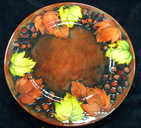 Appraisal: A Moorcroft Leaf and Berry flamb dish of crimson ground