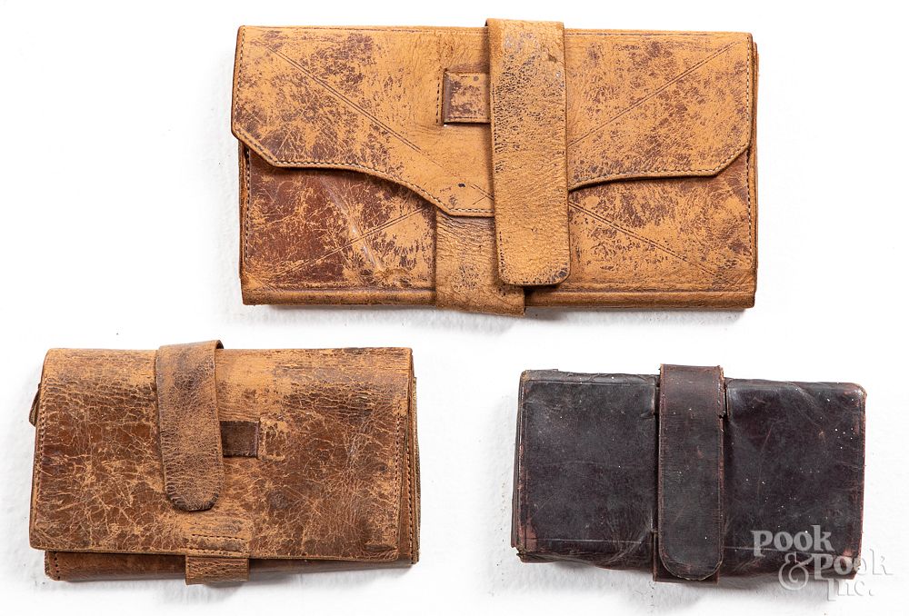 Appraisal: Three early leather pocketbooks Three early leather pocketbooks the largest