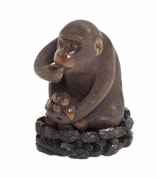 Appraisal: A Carved Wood Netsuke depicting a monkey with inlaid eyes