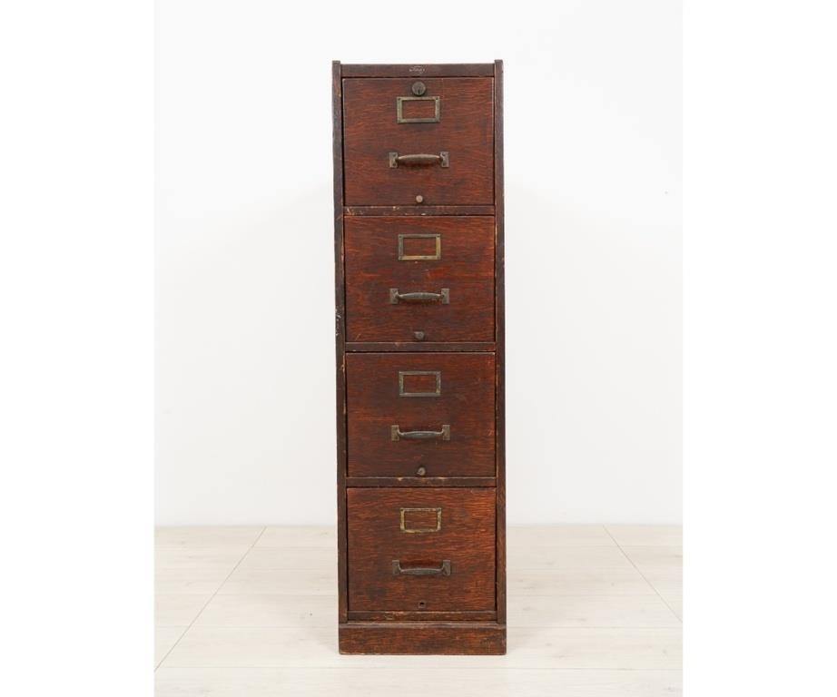 Appraisal: Oak four-drawer file cabinet by MACCY with Yale lock circa