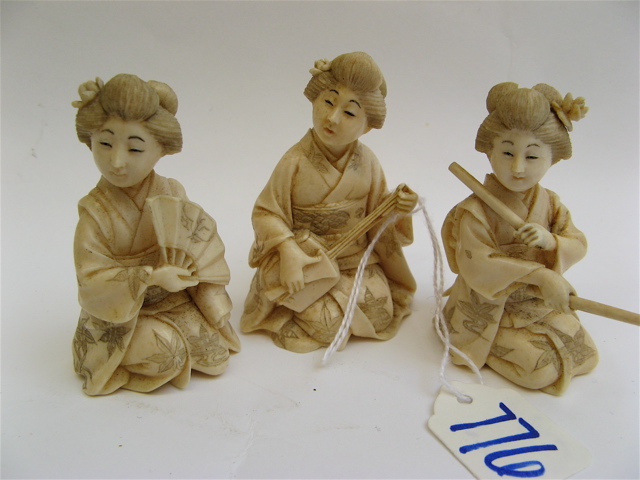 Appraisal: THREE JAPANESE IVORY CARVED FIGURES of seated women in traditional