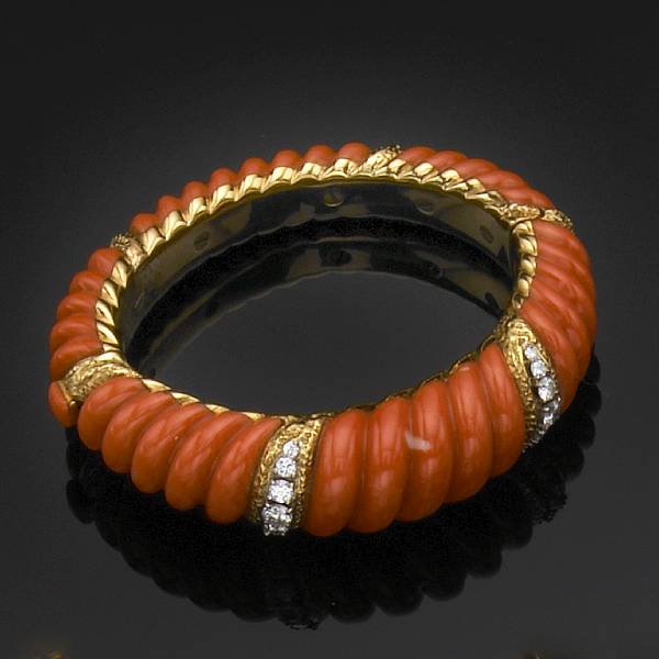 Appraisal: A coral diamond and gold hinged bangle featuring carved fluted