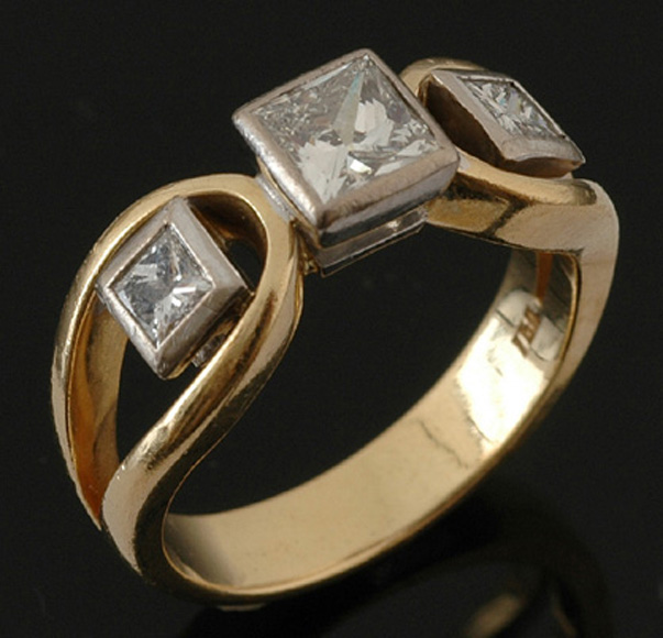 Appraisal: A three stone diamond ring Centrally set with a princess