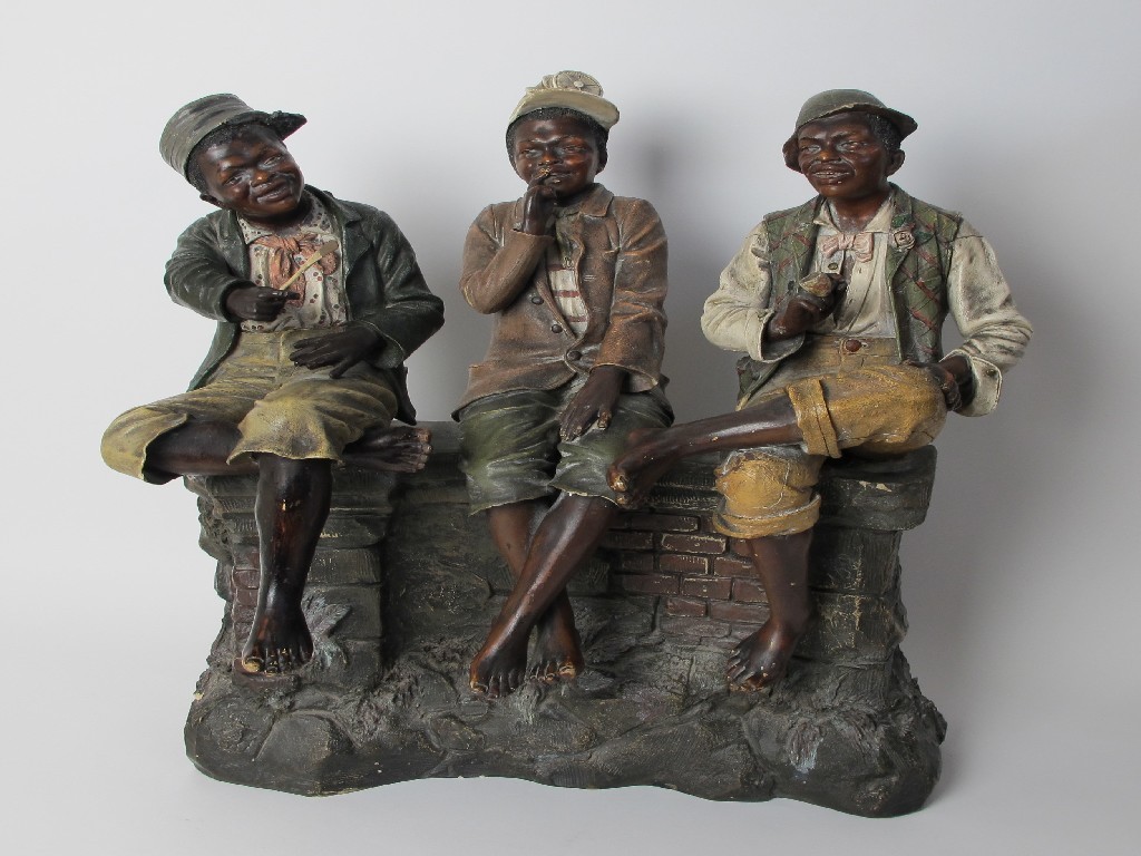 Appraisal: A Goldscheider style figure group of three boys sat upon