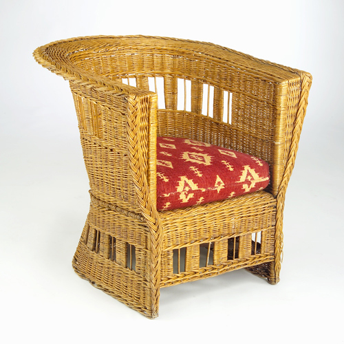 Appraisal: GUSTAV STICKLEY Skirted wicker chair with barrell-shaped back woven cut-outs