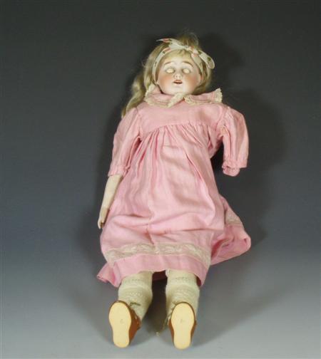 Appraisal: An early th century bisque doll with pink blouse leather