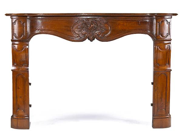 Appraisal: A Louis XIV XV transitional oak fireplace surround The serpentine