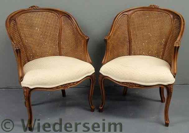 Appraisal: Pair of French fruitwood fauteuils with caned backs h x