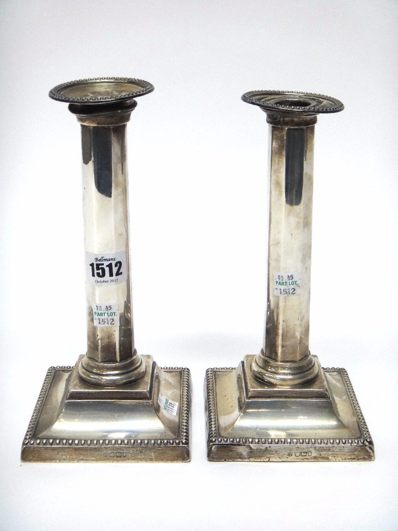 Appraisal: A pair of silver table candlesticks each with a tapering