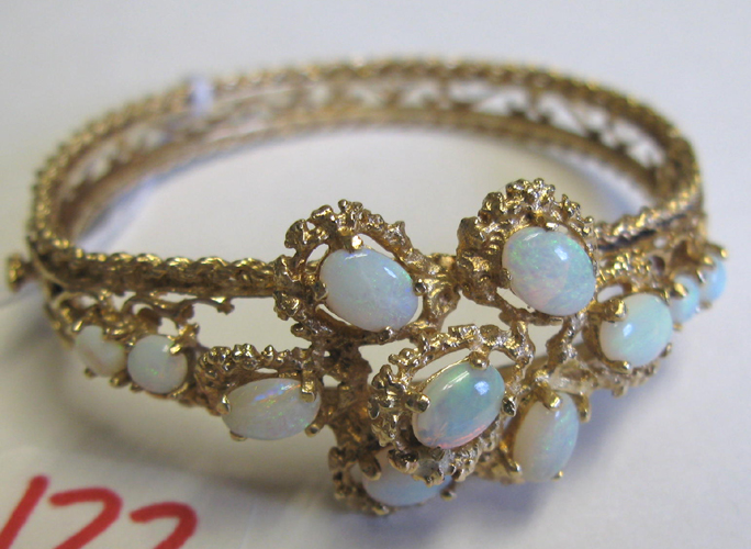 Appraisal: OPAL AND FOURTEEN KARAT GOLD BANGLE oval in shape and