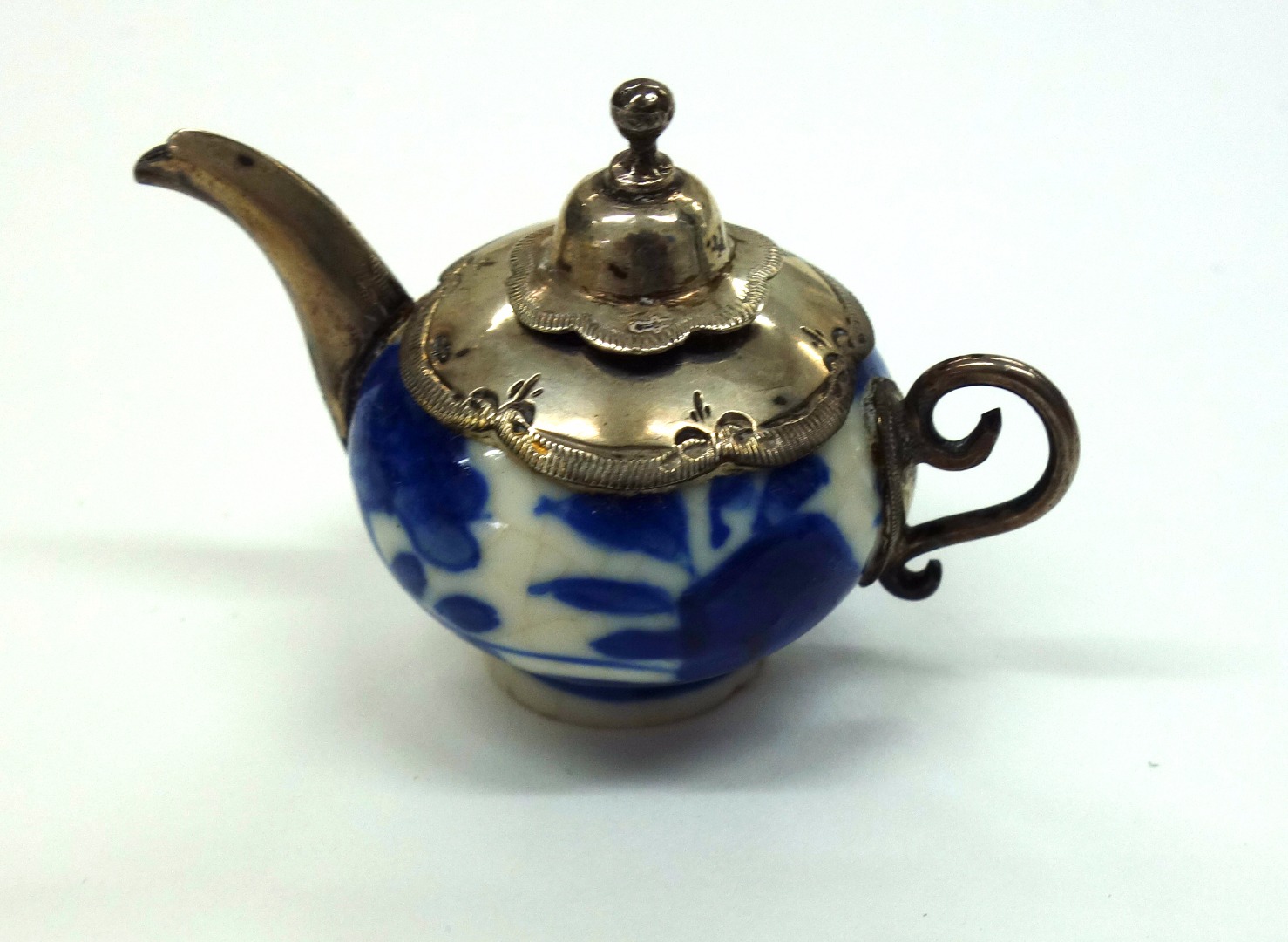 Appraisal: A miniature Dutch Delft blue and white teapot with silver