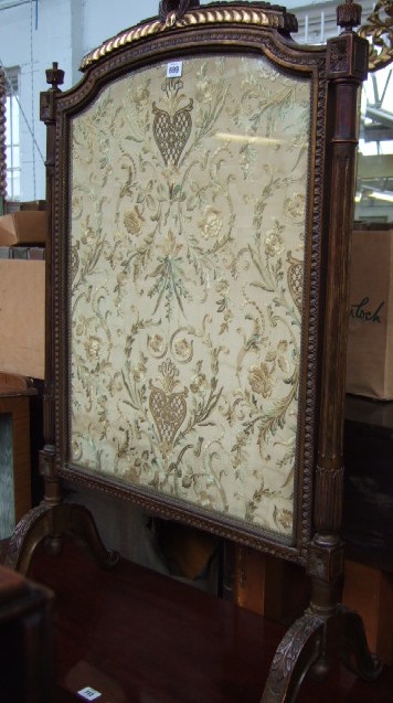 Appraisal: A carved and stained beechwood fire screen with a parcel