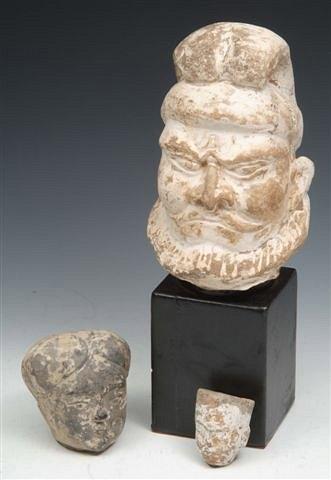 Appraisal: TWO CHINESE HAN POTTERY HEADS and a large Chinese head