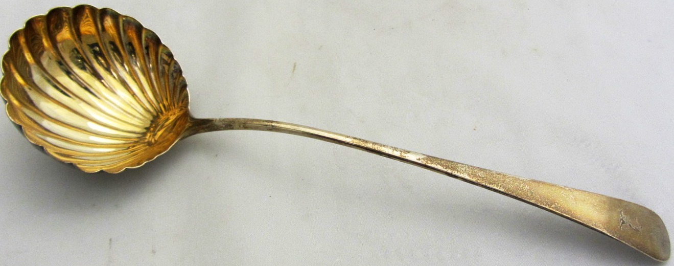 Appraisal: A George III silver shell pattern soup ladle crest engraved