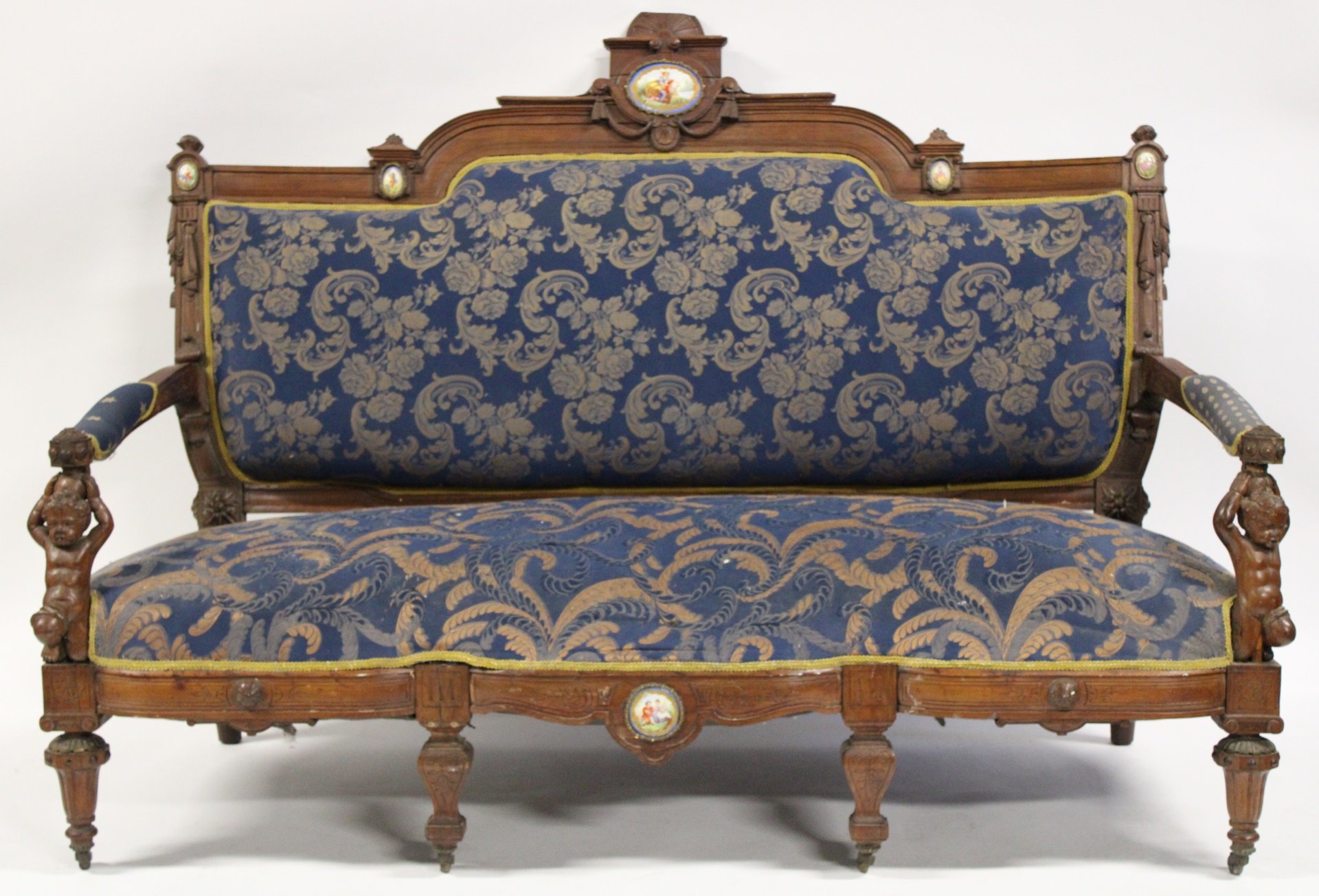 Appraisal: VICTORIAN WALNUT CARVED FIGURAL SOFA WITH Porcelain Plaques From a